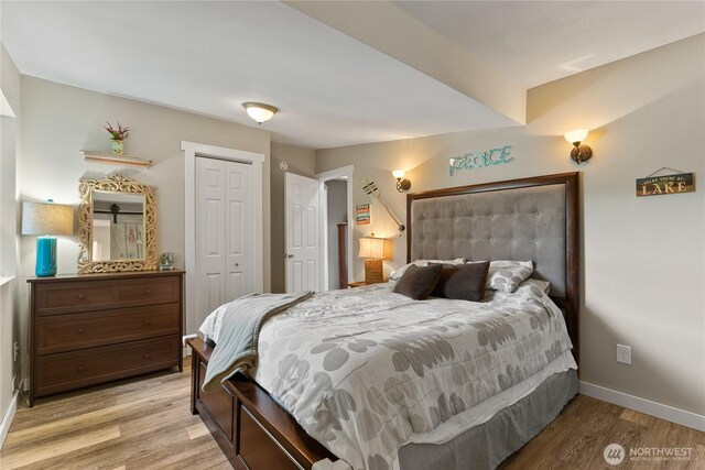bedroom with baseboards, light wood-style flooring, and a closet