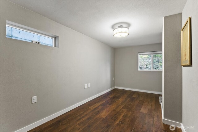 interior space featuring baseboards and dark wood finished floors