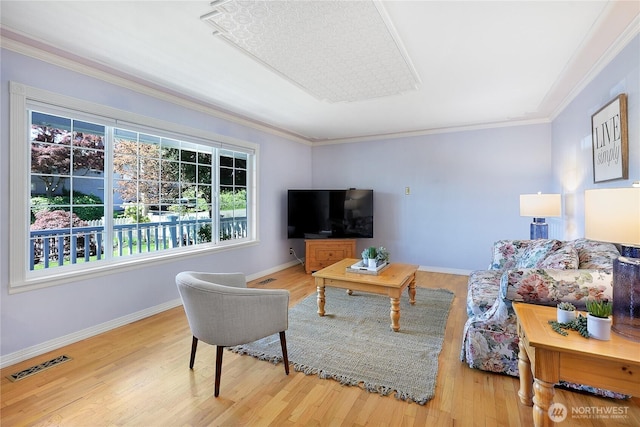 living room with ornamental molding, wood finished floors, and baseboards