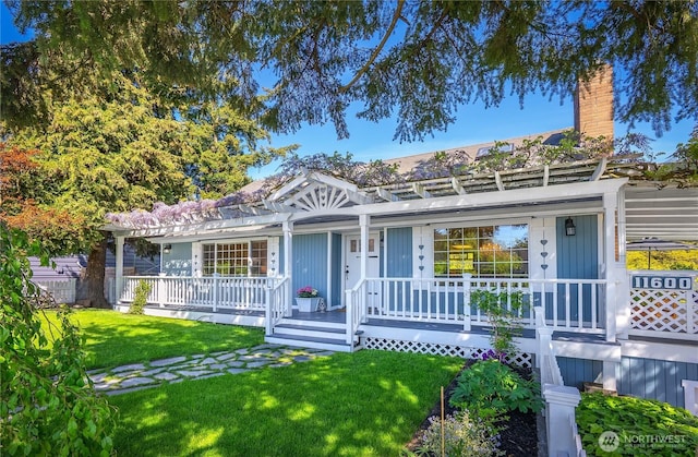 view of front of home featuring a porch, a front yard, and a chimney