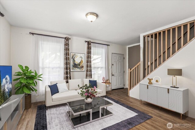living area featuring stairway and wood finished floors