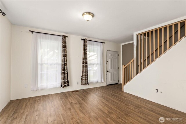 interior space with stairway, wood finished floors, and visible vents