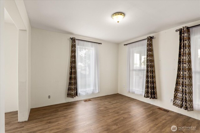 empty room with visible vents and wood finished floors