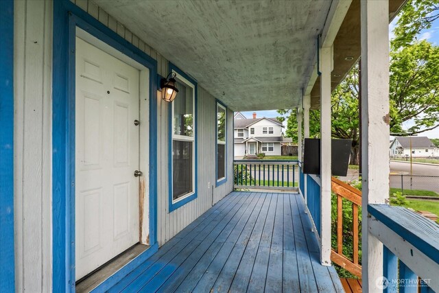 deck featuring covered porch and a residential view