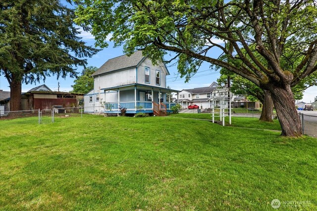 view of yard featuring a porch and fence
