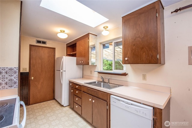 2916 SW 329th St, Federal Way, WA 98023 - kitchen with white appliances, a sink, light flooring, a skylight, and light countertops