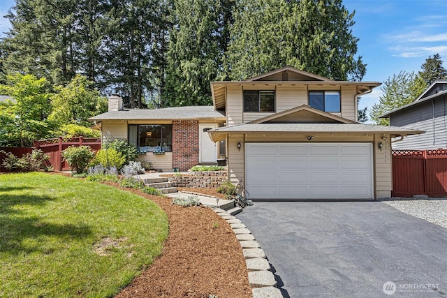 split level home with driveway, a chimney, and an attached garage