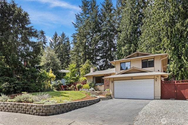 split level home featuring asphalt driveway and a garage