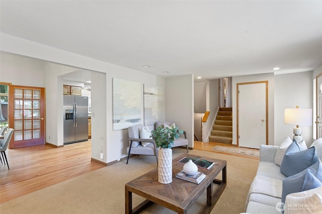 living area featuring stairway, recessed lighting, light wood-style floors, light carpet, and baseboards