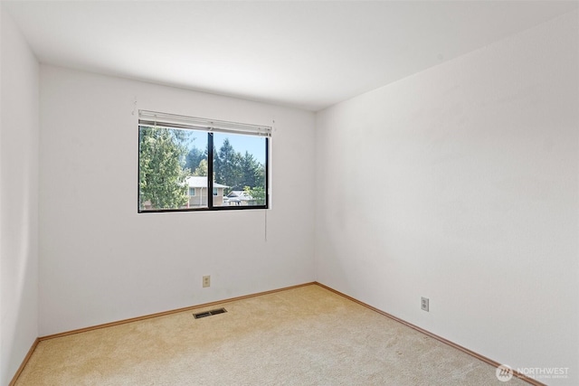 unfurnished room featuring light carpet and baseboards