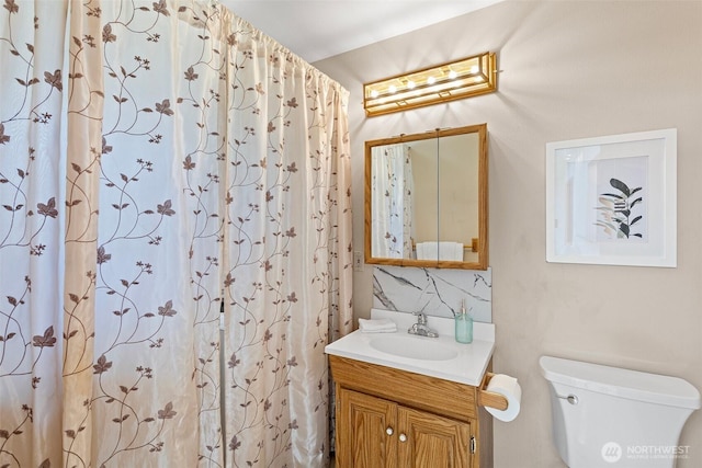 bathroom featuring toilet, vanity, backsplash, and a shower with shower curtain