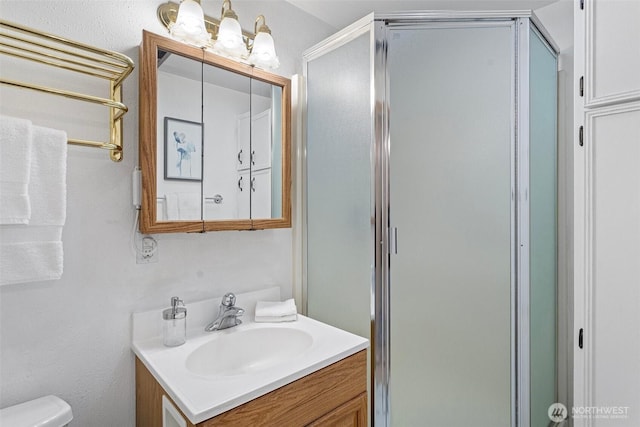 full bathroom with a stall shower, vanity, and toilet