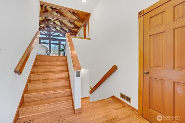 stairs with recessed lighting, baseboards, visible vents, and wood finished floors