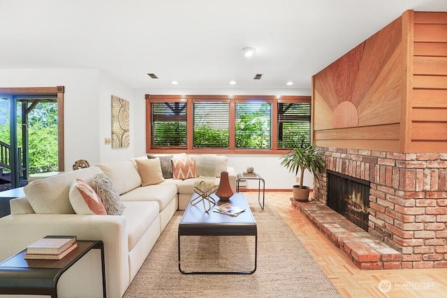 living room with recessed lighting, visible vents, and a fireplace