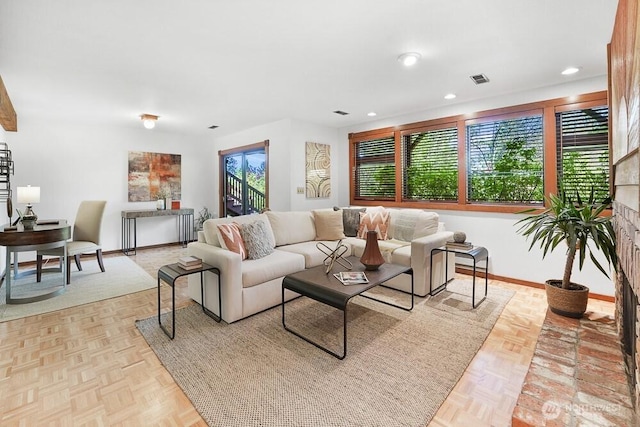 living room featuring baseboards, a brick fireplace, recessed lighting, and visible vents