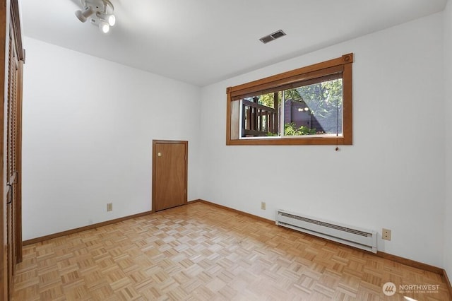 unfurnished room featuring visible vents, baseboards, and baseboard heating