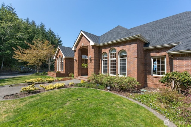 581 Harbor View Dr, Port Angeles, WA 98363 - view of front of home featuring brick siding, a shingled roof, and a front lawn
