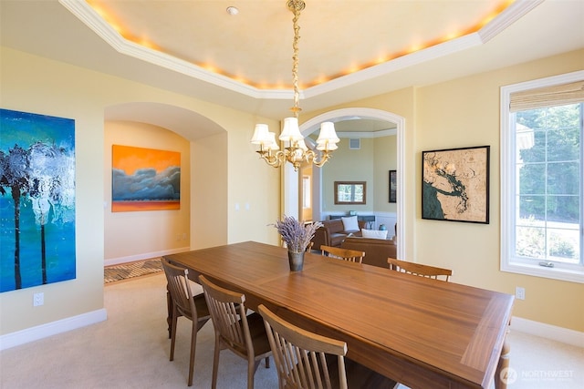 581 Harbor View Dr, Port Angeles, WA 98363 - dining area featuring a wealth of natural light, a tray ceiling, light colored carpet, and a notable chandelier