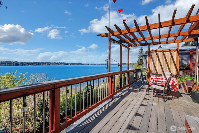deck with a water view and a pergola