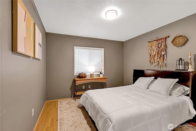 bedroom with a textured ceiling and wood finished floors