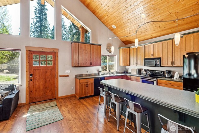 251 Kachess River Rd, Easton, WA 98925 - kitchen featuring black appliances, high vaulted ceiling, a kitchen bar, wooden ceiling, and light wood-style floors