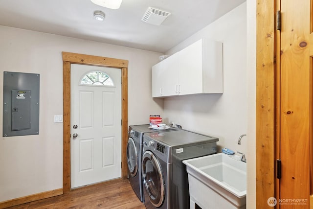 251 Kachess River Rd, Easton, WA 98925 - clothes washing area featuring electric panel, cabinet space, washing machine and clothes dryer, and wood finished floors