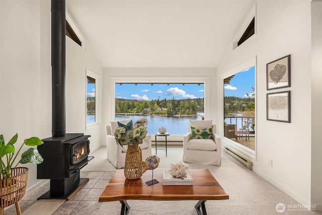sunroom / solarium with a water view, a baseboard radiator, and a wood stove