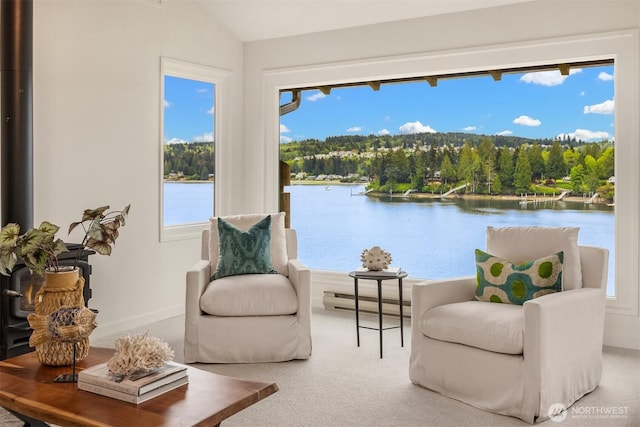 sitting room featuring baseboard heating, carpet floors, plenty of natural light, lofted ceiling, and a water view
