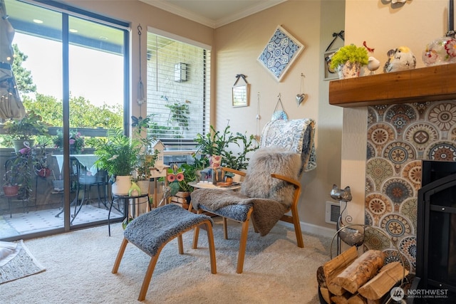sitting room with visible vents, carpet flooring, and ornamental molding