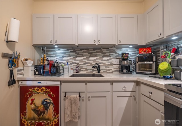 kitchen with a sink, backsplash, and light countertops