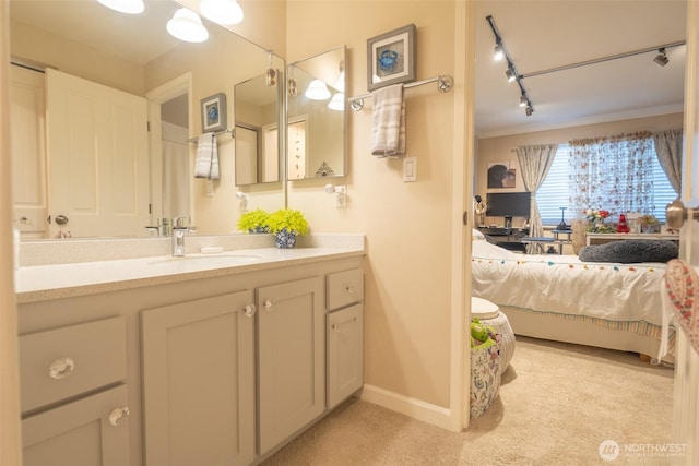bathroom featuring crown molding, rail lighting, vanity, baseboards, and connected bathroom