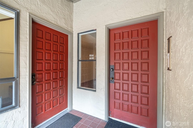 doorway to property featuring stucco siding