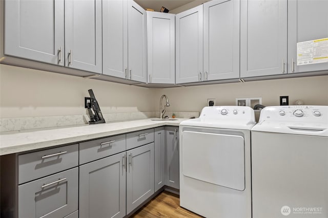 10871 Alfred St, Rockport, WA 98283 - washroom featuring light wood-style flooring, a sink, cabinet space, and washer and clothes dryer