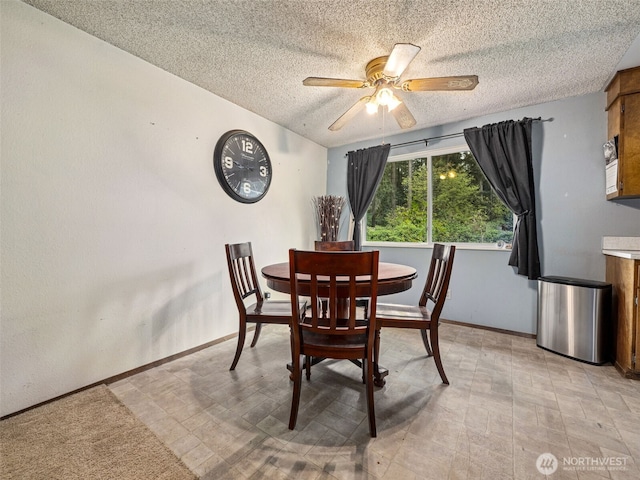 dining space featuring a ceiling fan, a textured ceiling, and baseboards