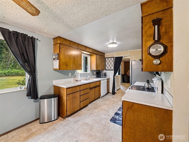 kitchen with light countertops, appliances with stainless steel finishes, and brown cabinets