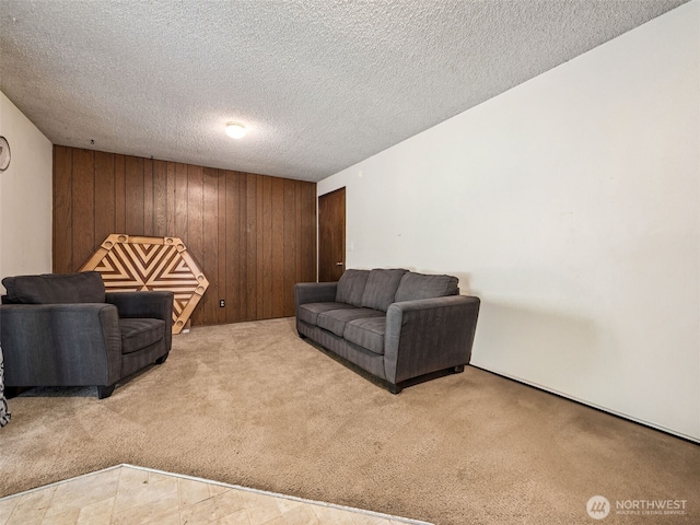 carpeted living area featuring a textured ceiling and wooden walls