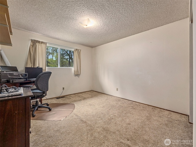 carpeted office space with a textured ceiling and visible vents