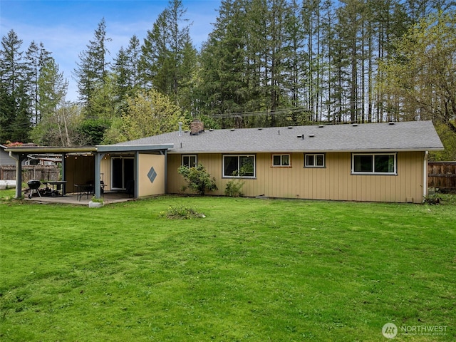 back of property featuring a yard, fence, and a patio area