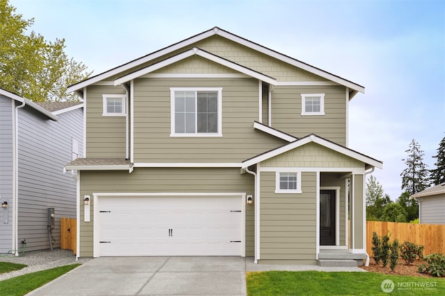 view of front of home with fence, concrete driveway, and an attached garage