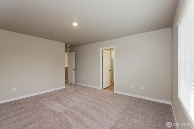 empty room with baseboards and light carpet