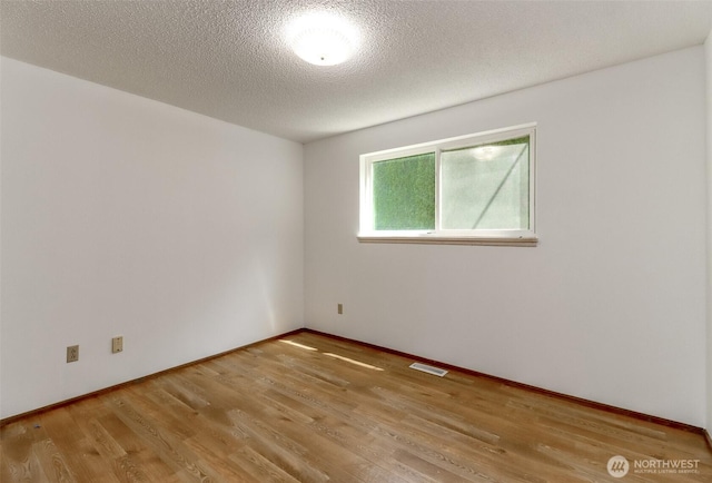 unfurnished room featuring wood finished floors and a textured ceiling