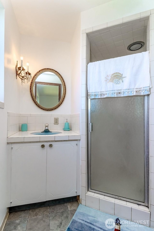 full bath with a stall shower and vanity