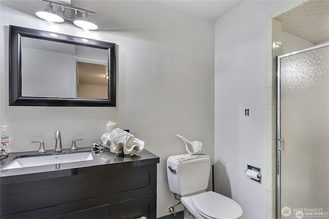 full bath featuring toilet, a stall shower, and vanity