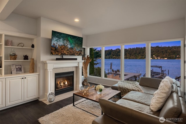 living room with dark wood-style flooring, recessed lighting, and a tile fireplace