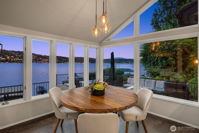 sunroom / solarium with plenty of natural light, a water view, and a notable chandelier