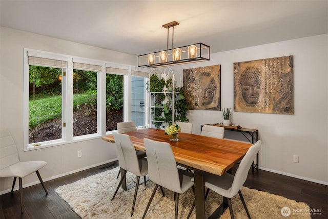 dining area featuring an inviting chandelier, hardwood / wood-style flooring, baseboards, and a healthy amount of sunlight