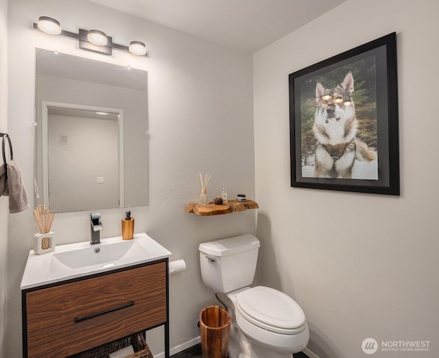bathroom with vanity, toilet, and baseboards