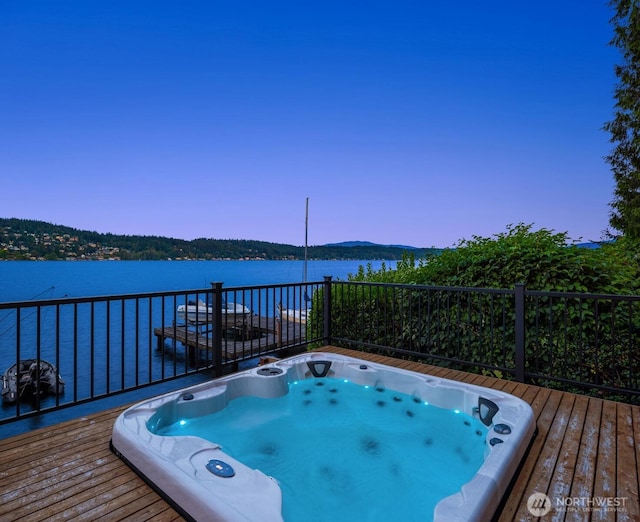 wooden terrace with a water view and hot tub deck surround