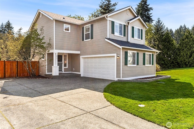 traditional-style home featuring concrete driveway, fence, a front yard, and a garage
