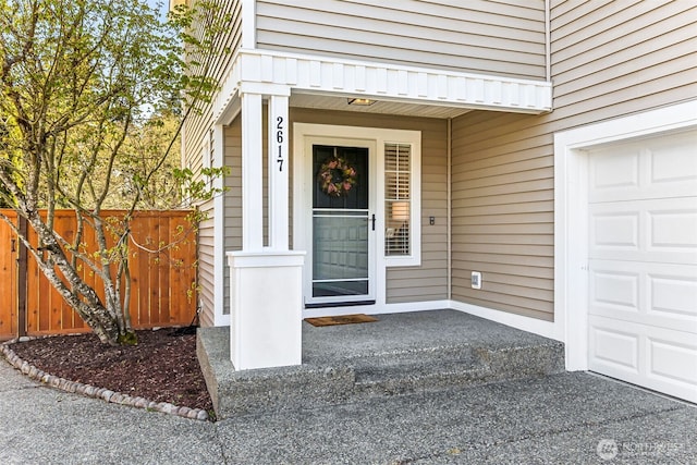 doorway to property with fence and a garage